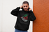 products/heathered-hoodie-pullover-mockup-of-a-man-leaning-on-a-bicolor-wall-28627.png