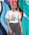 products/tee-mockup-of-a-smiling-girl-in-front-of-a-wall-with-colorful-illustrations-26646.png